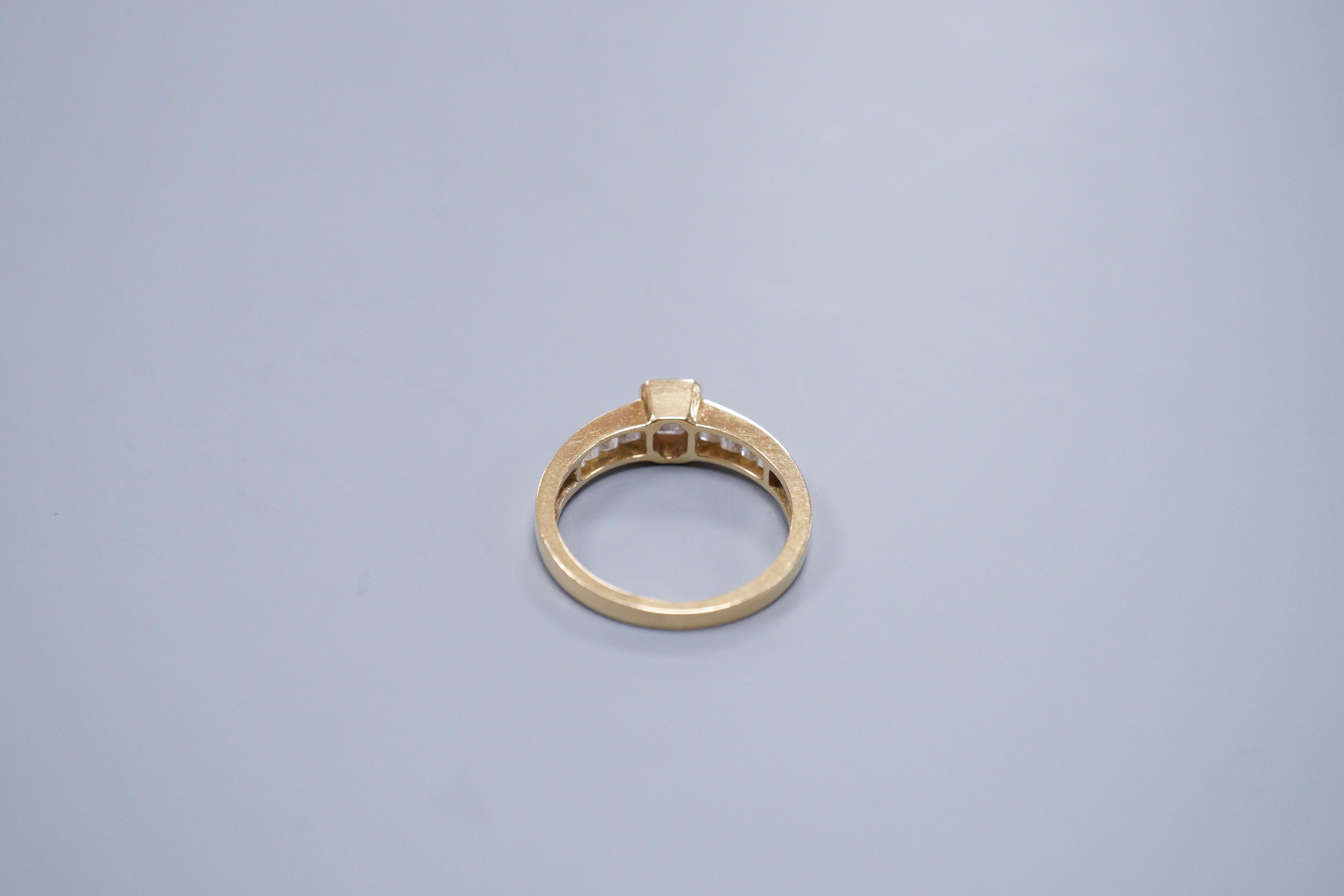 Am 18ct gold and diamond dress ring, with central octagonal cut stone and emerald cut shoulders, size O, gross weight 3.4 grams